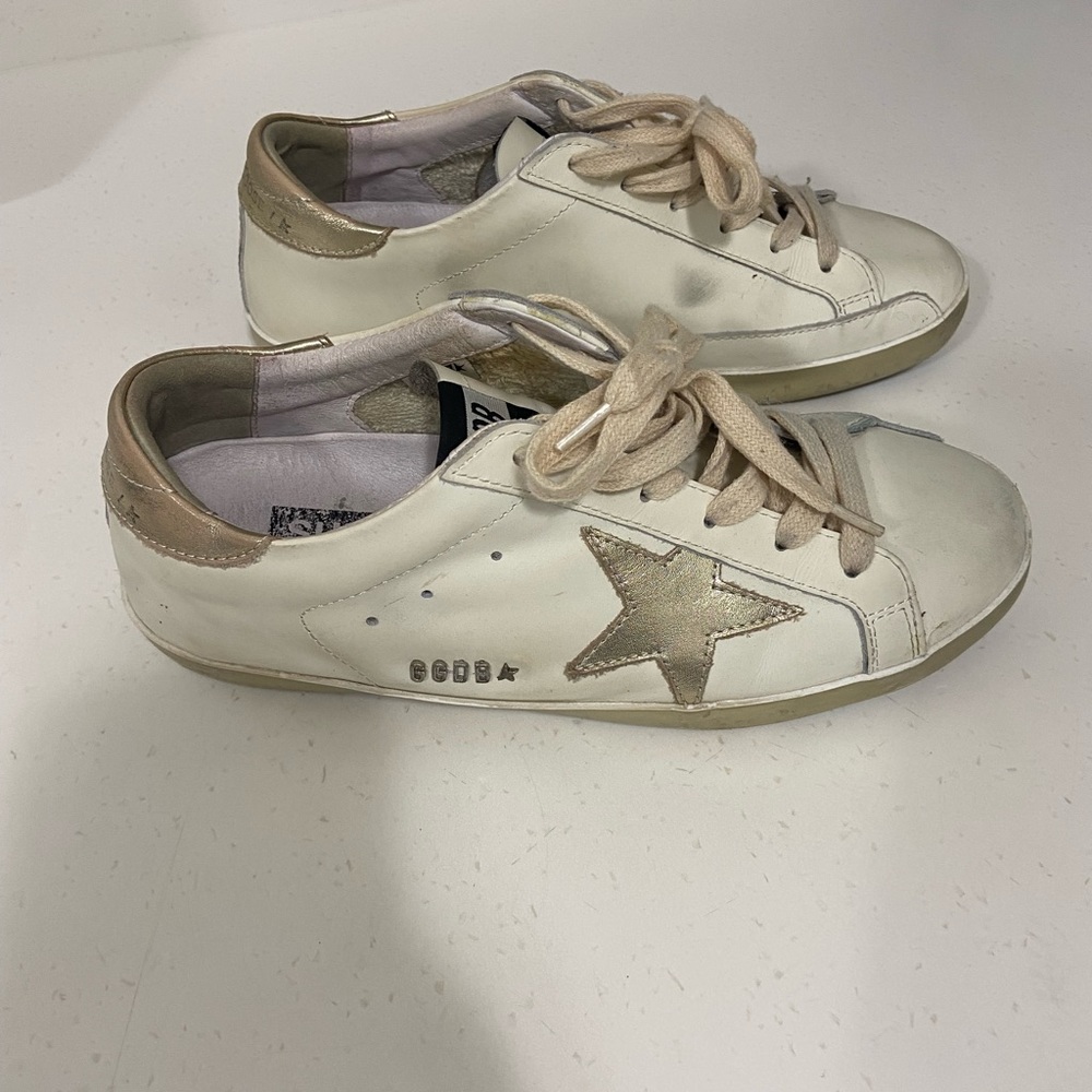 White sneakers with gold star.